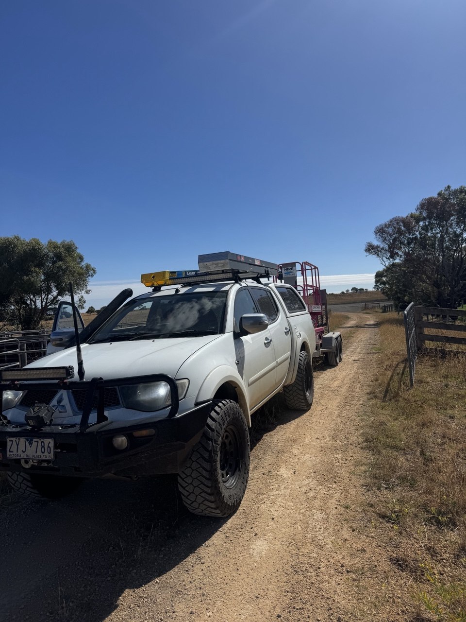 LWElectrical work ute and scissor lift on a rural job site